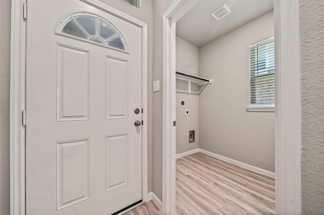 laundry room with electric dryer hookup and light wood-type flooring