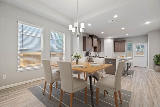 dining area featuring light hardwood / wood-style floors, a notable chandelier, and a wealth of natural light