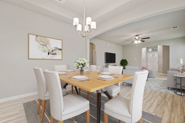 dining space featuring light hardwood / wood-style floors and ceiling fan with notable chandelier