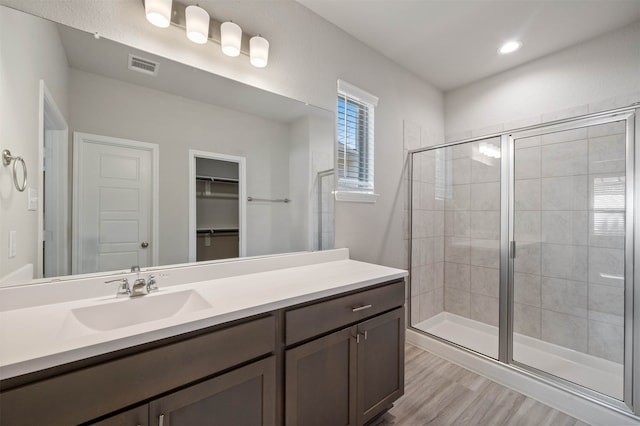 bathroom featuring vanity, an enclosed shower, and wood-type flooring