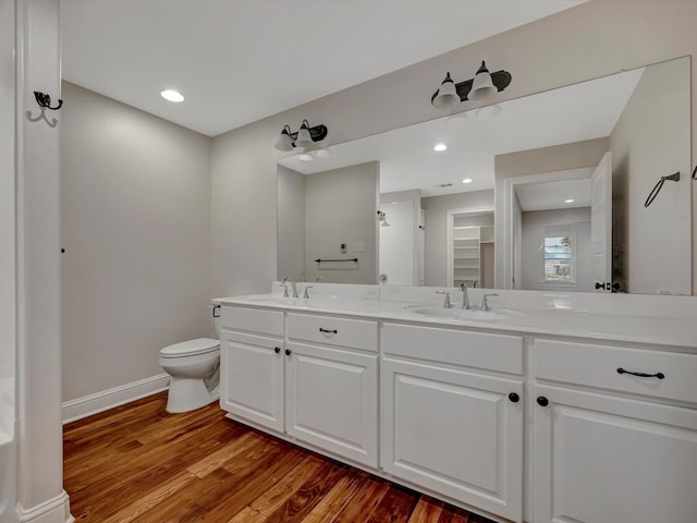 bathroom with toilet, hardwood / wood-style flooring, and vanity