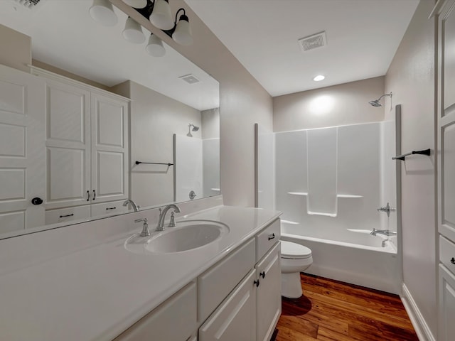 full bathroom with toilet, hardwood / wood-style floors, vanity, and shower / bath combination