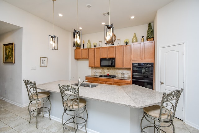 kitchen featuring black appliances, sink, an island with sink, pendant lighting, and decorative backsplash