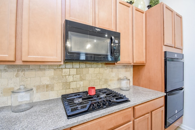 kitchen with backsplash, black appliances, and light brown cabinetry