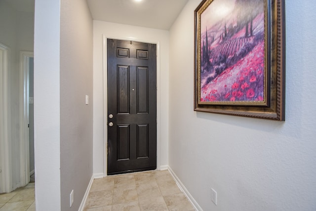 doorway to outside with light tile patterned flooring