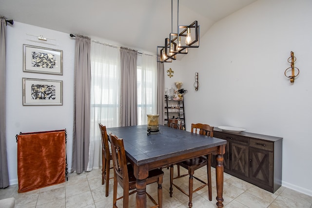 tiled dining area featuring lofted ceiling and an inviting chandelier