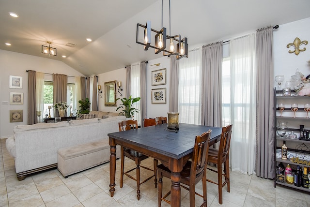 tiled dining area featuring an inviting chandelier and lofted ceiling