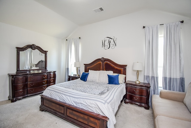 bedroom with vaulted ceiling and light colored carpet