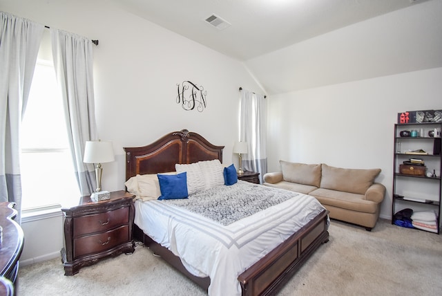 bedroom with lofted ceiling and light colored carpet