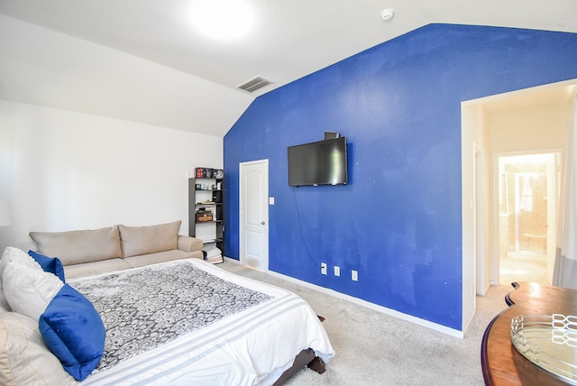 carpeted bedroom featuring vaulted ceiling and ensuite bathroom