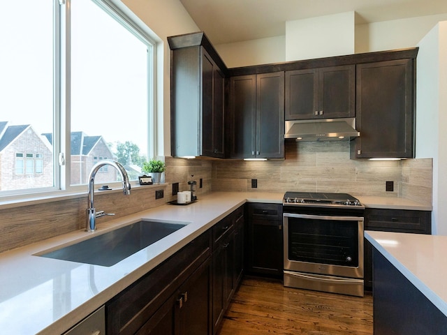 kitchen featuring tasteful backsplash, sink, dark brown cabinets, stainless steel stove, and dark wood-type flooring