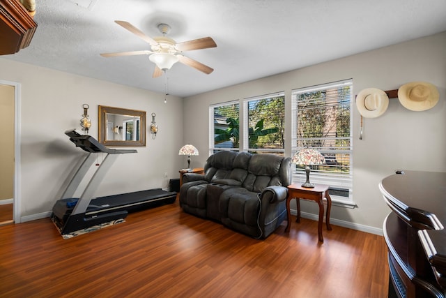 workout area with ceiling fan, a textured ceiling, and hardwood / wood-style floors