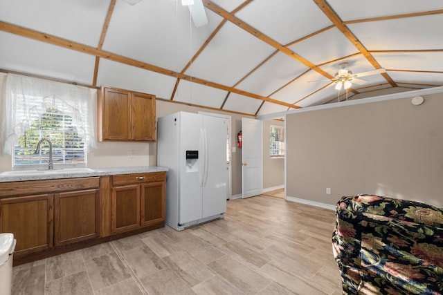 kitchen with lofted ceiling, sink, white refrigerator with ice dispenser, and ceiling fan