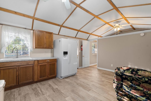 1726 Bowler Rd, Waller, TX 77484 - kitchen featuring white refrigerator with ice dispenser, ceiling fan, brown cabinetry, and a sink