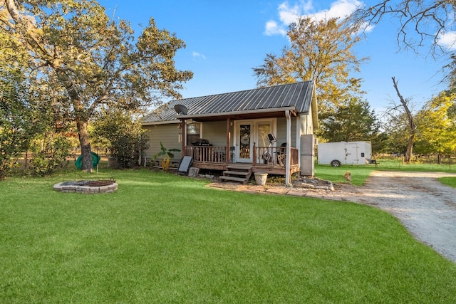 1726 Bowler Rd, Waller, TX 77484 - rear view of property featuring a lawn, metal roof, and a fire pit
