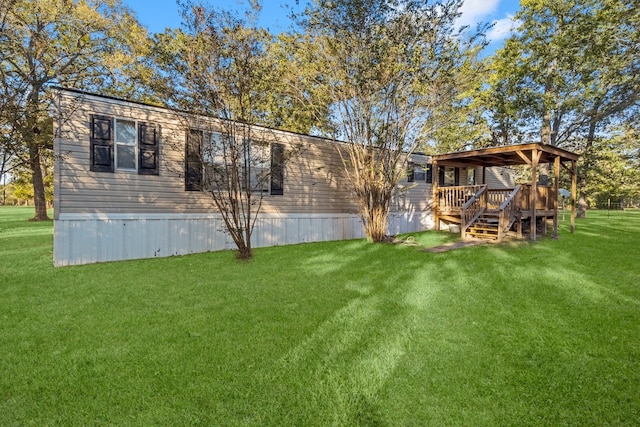 back of property featuring a wooden deck and a yard