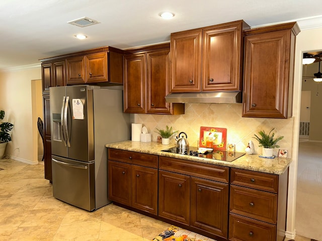 kitchen featuring light stone countertops, stainless steel fridge, backsplash, black electric cooktop, and crown molding