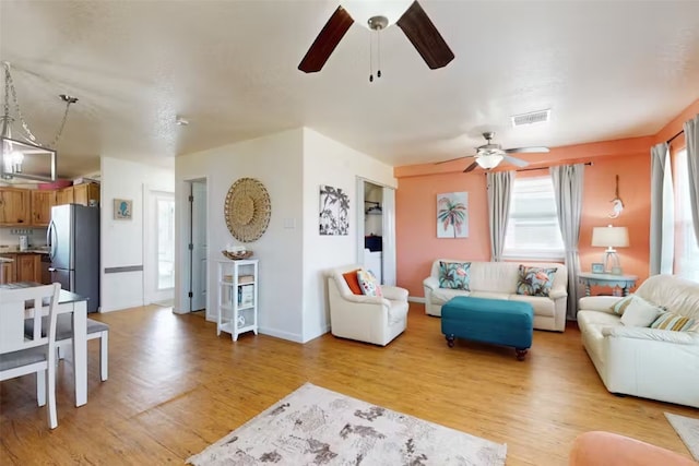 living room with ceiling fan and light hardwood / wood-style floors