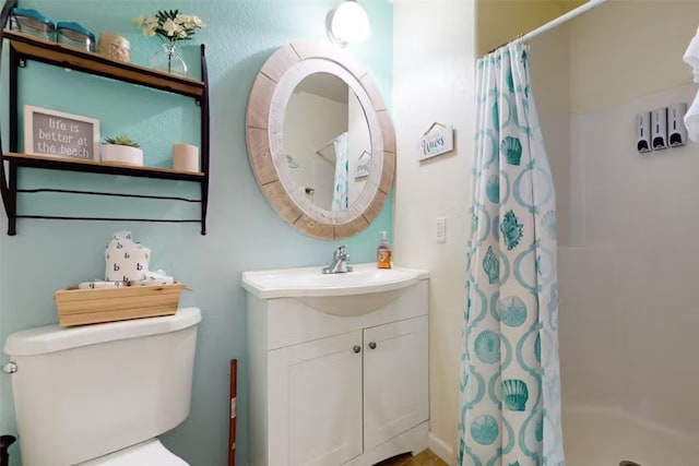 bathroom with a shower with shower curtain, vanity, and toilet