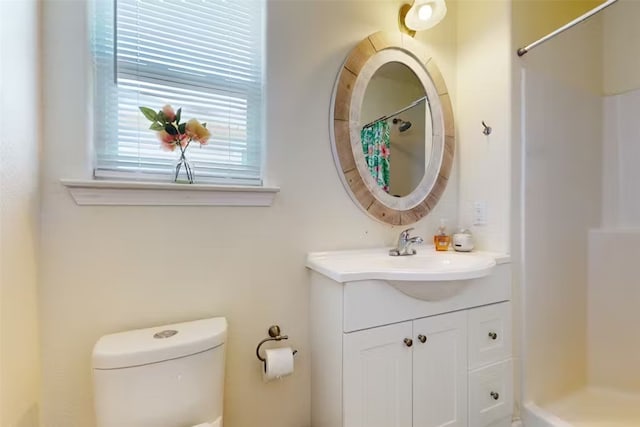 bathroom with toilet, vanity, and a shower with shower curtain