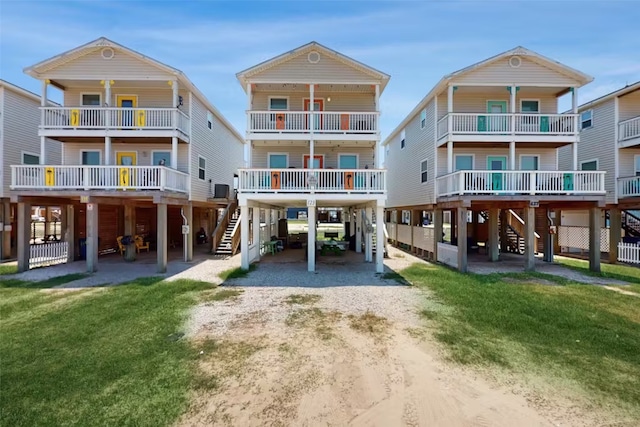 rear view of property featuring a carport, a yard, and a balcony