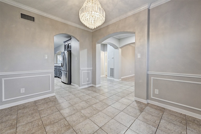 empty room featuring crown molding, a notable chandelier, and light tile patterned floors