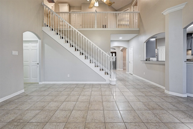 foyer entrance featuring light tile patterned flooring, a high ceiling, and ceiling fan