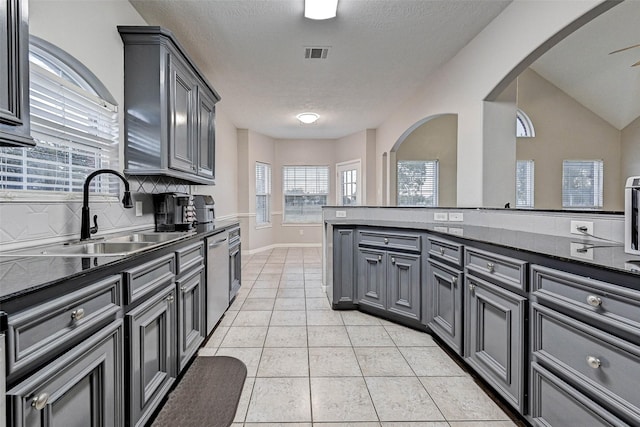6530 Fm 3180 W, Mont Belvieu, TX 77523 - kitchen with a sink, arched walkways, gray cabinetry, dark countertops, and light tile patterned flooring