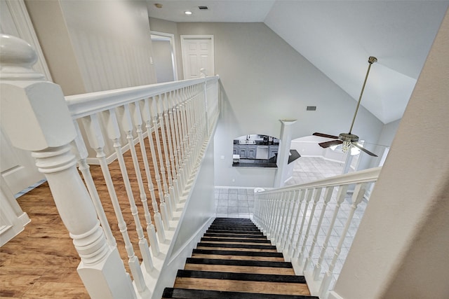 stairway with lofted ceiling, wood-type flooring, and ceiling fan