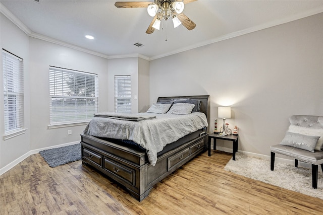 bedroom with light hardwood / wood-style floors, crown molding, and ceiling fan