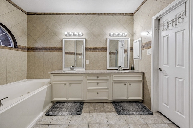 bathroom featuring tile walls, vanity, a bathtub, and tile patterned flooring