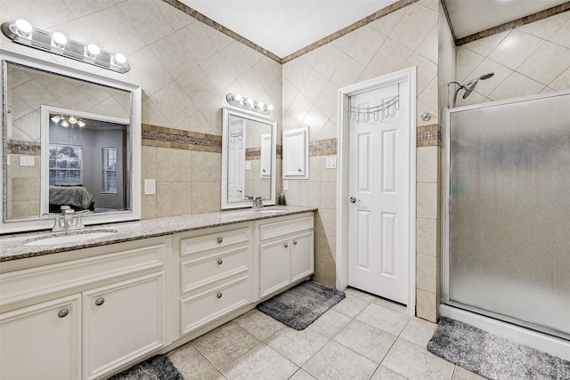 bathroom with a shower with door, tile walls, vanity, ornamental molding, and tile patterned flooring