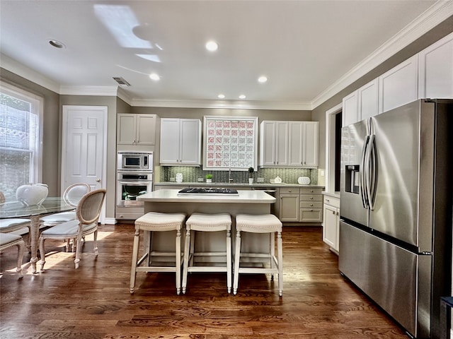 kitchen featuring white cabinetry, a kitchen breakfast bar, stainless steel appliances, and a center island