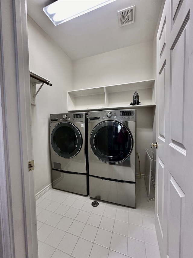 clothes washing area with separate washer and dryer and light tile patterned floors