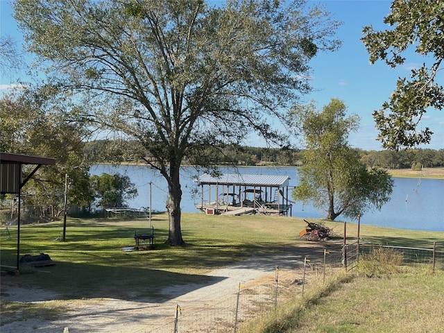 dock area featuring a lawn and a water view