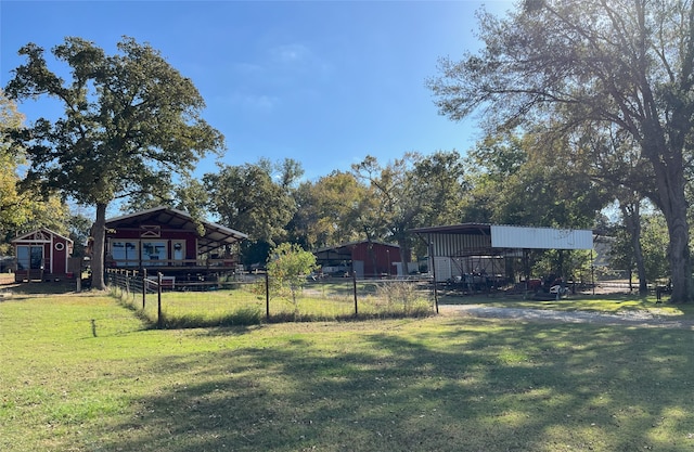 view of yard with a carport and an outbuilding