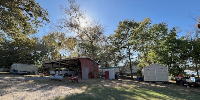 view of yard featuring a carport and a shed