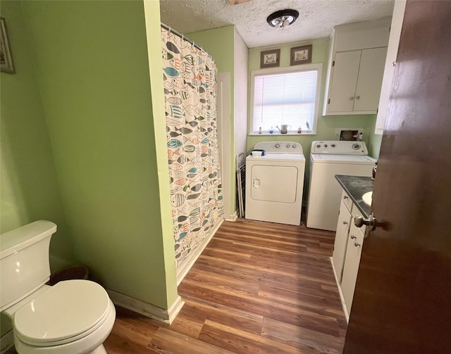 bathroom featuring vanity, a textured ceiling, hardwood / wood-style floors, independent washer and dryer, and toilet