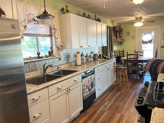 kitchen featuring pendant lighting, white cabinets, black dishwasher, a textured ceiling, and stainless steel refrigerator