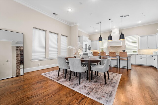 dining space featuring ornamental molding and dark wood-type flooring