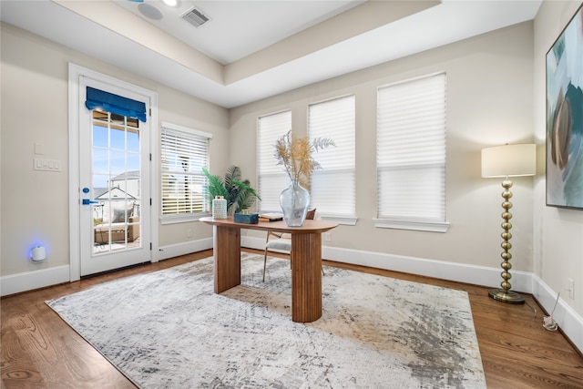 home office featuring a raised ceiling and hardwood / wood-style floors