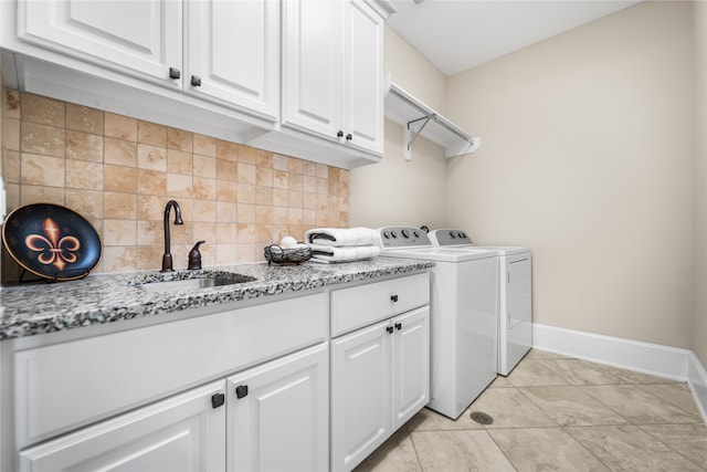 laundry room with cabinets, light tile patterned flooring, sink, and separate washer and dryer