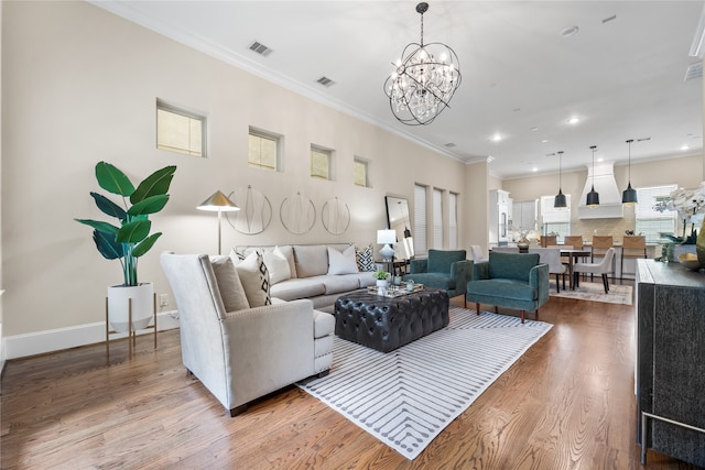 living room with ornamental molding, light hardwood / wood-style flooring, and a notable chandelier