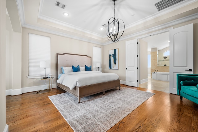 bedroom featuring ensuite bathroom, wood-type flooring, ornamental molding, and a chandelier