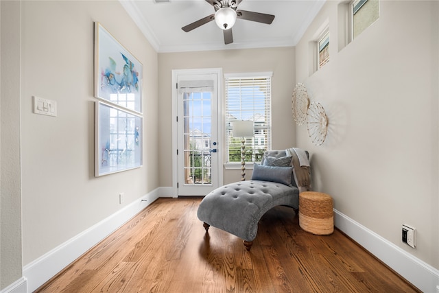 living area with ornamental molding, light hardwood / wood-style floors, and ceiling fan