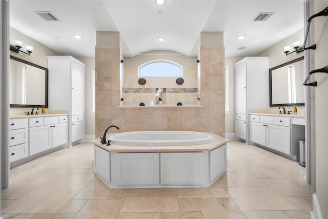 bathroom with vanity, a tub to relax in, and lofted ceiling