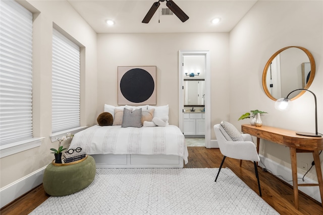 bedroom with ensuite bathroom, hardwood / wood-style flooring, and ceiling fan