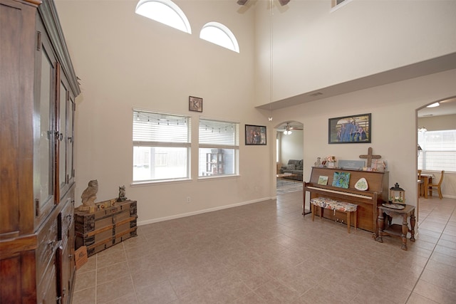 tiled entrance foyer featuring a towering ceiling and ceiling fan