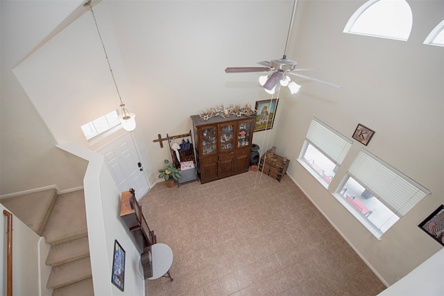 living room featuring a high ceiling and ceiling fan