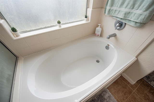 bathroom with a tub and tile patterned flooring